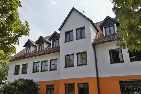 Das Praxisgebäude an der Truderinger Straße von außen, mit Bäumen davor